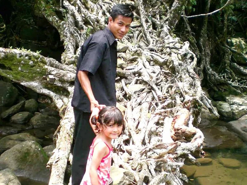 Noëmi crosses a root bridge with a local guide in Meghalaya. (2006) Image